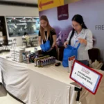 Meja konsumsi dan goodie bag dalam acara Donor Darah Rumah Berkat ke-9, dengan staf yang sedang mempersiapkan paket untuk peserta.