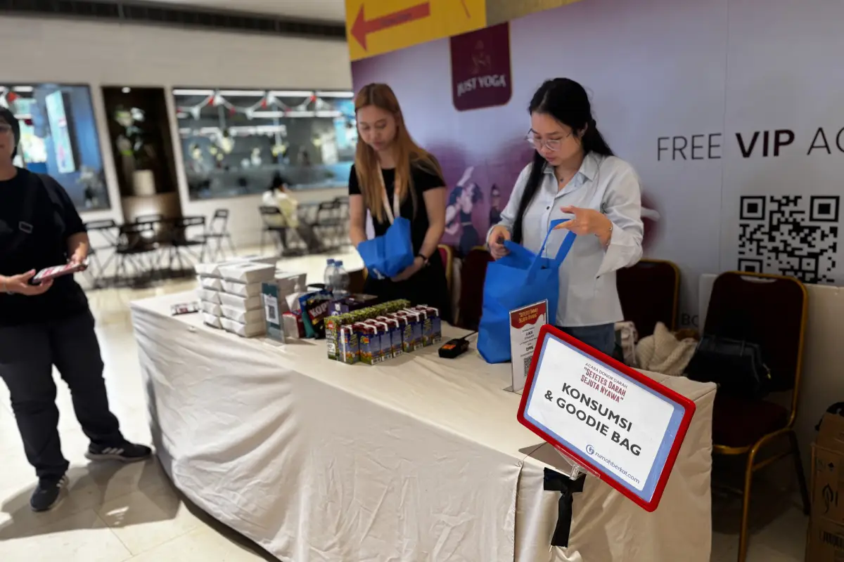 Meja konsumsi dan goodie bag dalam acara Donor Darah Rumah Berkat ke-9, dengan staf yang sedang mempersiapkan paket untuk peserta.